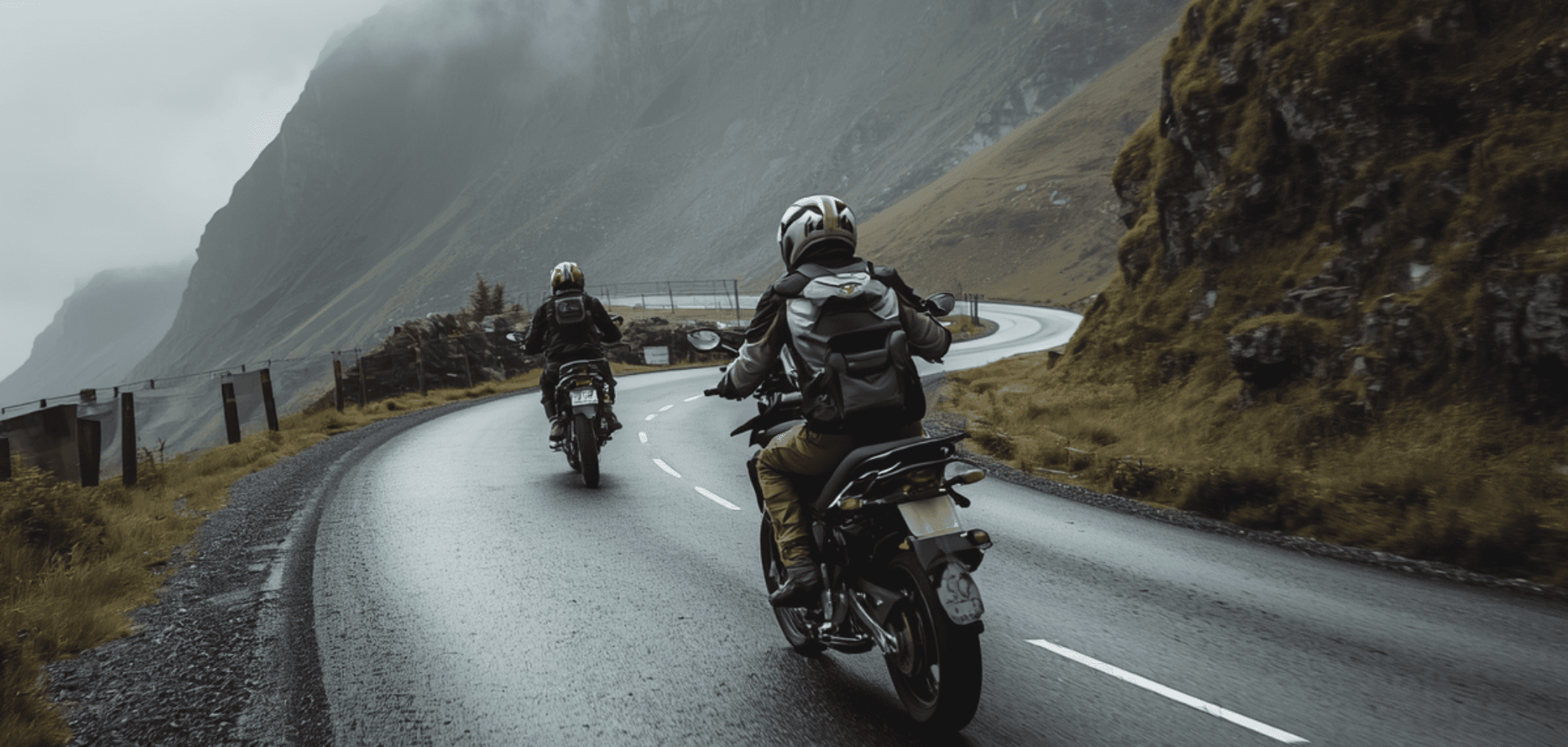 Motorcyclists riding through mountain roads beside a lake